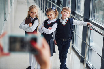 School kids in uniform making a photo together in corridor. Conception of education