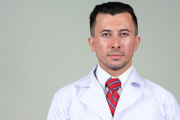 Portrait of young handsome man doctor looking at camera