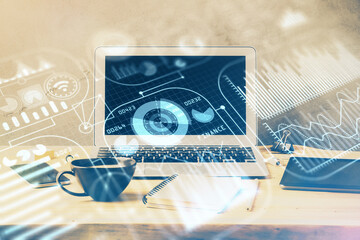 Computer on desktop in office with technology theme hologram. Multi exposure. Tech concept.