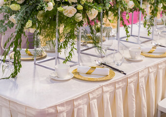 luxury wedding decor with flowers and glass vases and number of setting on round tables