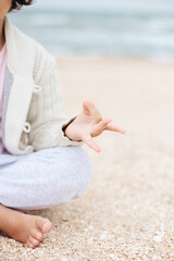 little girl meditating on the beach
