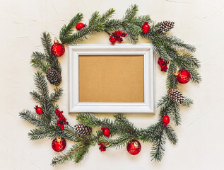 Fototapeta na wymiar Christmas light background, fir branches wreath with red baubles and berries, beautiful frame and copy space for your text. White creative layout, flat lay, top view.