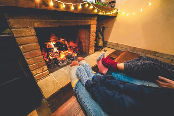 Legs view of happy family lying down next fireplace wearing warm wool socks - Winter, holiday,...