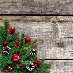 Christmas background, old wood texture, festive corner decorate. Pine fir leaf, cones, red golden balls, baubles, berries, candy, gift box. Xmas, New Year wallpaper, greeting card, top view flat lay.