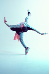 Young man breakdancer performs trick in jump dancing in studio in neon light. Break dance lessons. Dance school poster