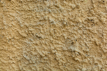 Beautiful wall with decorative stone on a yellow cement wall. Light brown concrete stone wall texture for background