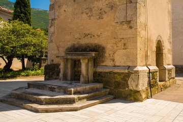 An historic stone altar next to the bell tower of Saint Vitus parish church in Podnanos, a village in the upper Vipava Valley in the Municipality of Vipava in the Primorska region of Slovenia. The chu