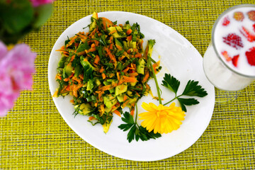 Salad on a plate, a glass of fruit and berry cocktail, flowers blurred background. Healthy vitamin Breakfast. Diet food for weight loss.