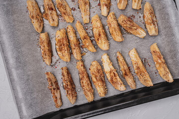 
Fresh eggplant in breadcrumbs on a baking sheet. Top view.