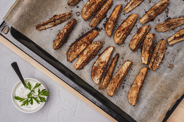 
Healthy eating. Fresh eggplant in breadcrumbs on a baking sheet.