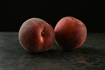 Fototapeta na wymiar two peaches on a dark background