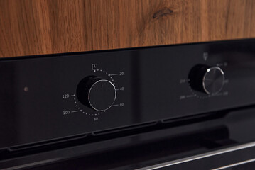 Fototapeta premium Close up view of gas stove knobs indoors in the kitchen. Wooden material