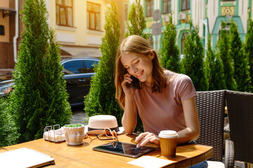 young woman using tablet pc in a cafe on a summer terrace