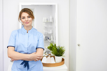 Happy successful young woman cosmetologist on the background of the beauty office. Portrait of...