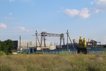 Fototapeta na wymiar technical structures crane hangar poles barrels tanks General plan in summer