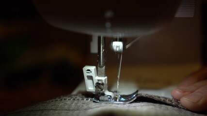 On a sewing machine sew clothes close-up. Dressmaker sews fabric.