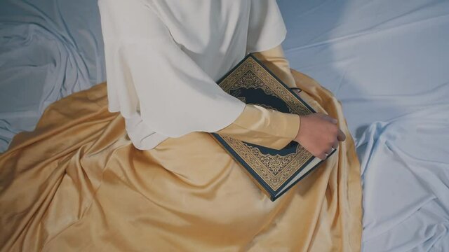 Asian muslim young woman sitting open and reads a koran book, Study education of religious teachings