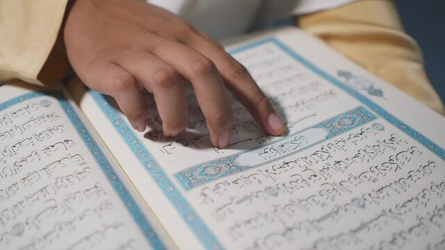 Asian muslim young woman sitting reads a koran book indoors at home, Study education of religious teachings