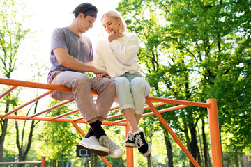Happy teen couple on playground in a city park