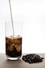 milk poured into iced coffee