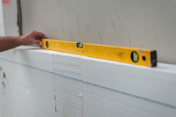 Construction worker checking the level of styrofoam block