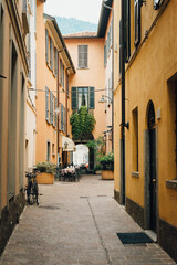 Fototapeta na wymiar Como city - old small town in Italy - empty street with street cafe