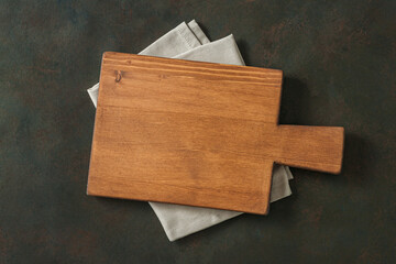 Wood cutting board over towel on stone kitchen table