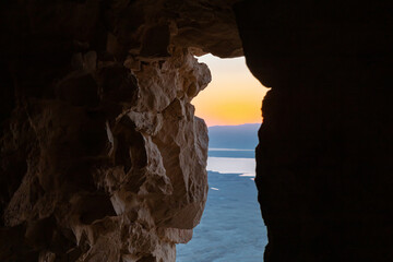 Dawn  through a breach in the wall at the Massada Ruins, a fortress built by Herod the Great on a...