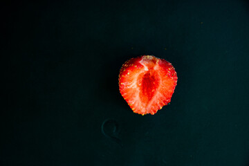 Half a strawberry on a black background