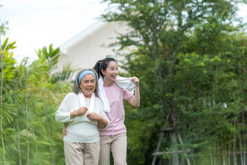 Smile young woman take care hug happy elder after running (cool down) in the morning exercise in the park.