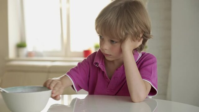 7 year old caucasian boy refuses to eat soup. Child hate soup.