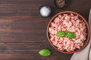 Raw minced meat in bowl on wooden table