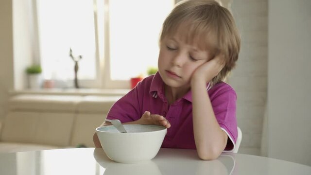 7 year old caucasian boy refuses to eat soup. Child hate soup.
