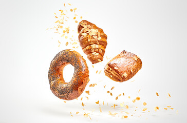 Croissant bun brioche cake flying in air. Fresh baked puff pastry cookie falling on white....