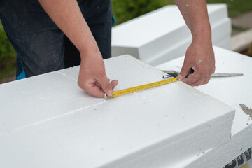 Man measuring styro foam with measuring tape