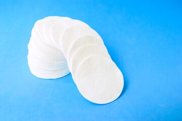 Cotton cotton cotton discs on a blue background. Cosmetology and medicine. Taking care of yourself.