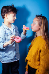 happy family brother and sister eating donuts on blue background, lifestyle people concept, boy and girl eating unhealthy food
