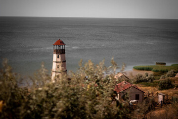 Fototapeta na wymiar Lighthouse by the sea with houses