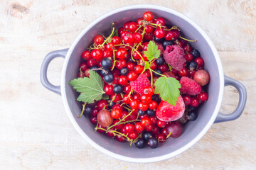 mixed berries in a bowl on wooden table