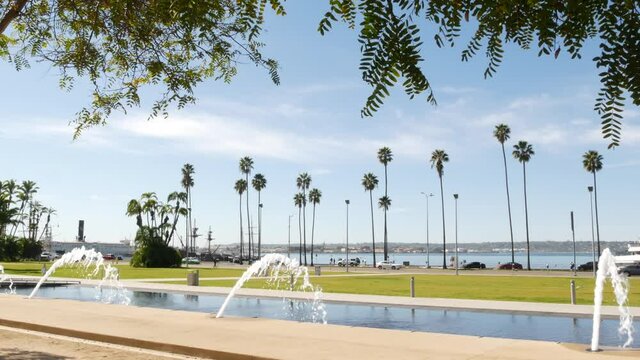 Fountain in waterfront city park near San Diego county civic center in downtown, California government authority, USA. Pacific ocean harbour, embarcadero in Gaslamp Quarter. Palms and grass near pier.
