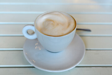 Italian cappuccino on a white slatted table