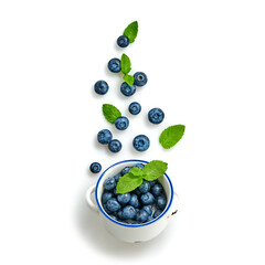 Blueberry flying in air, isolated on white. Fresh blueberry falling into bowl closeup, healthy diet concept. Ripe organic bilberry, mint leaf fly, creative minimal levitation concept.