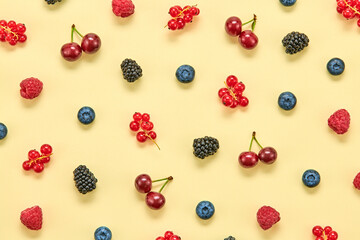 Blueberry, raspberry, blackberry, redcurrant, cherry colorful pattern on yellow background. Fresh blueberry wallpaper, top view. Creative concept, fashion trendy flat lay