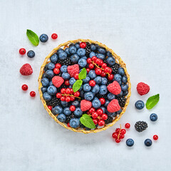 Blueberry, raspberry, blackberry, redcurrant in basket. Fresh blueberry, berries mix on marble. Red raspberry, blue blackberry, mint creative composition. Colorful trendy concept, top view.
