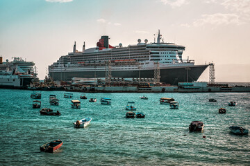 huge cruise liner and small boats