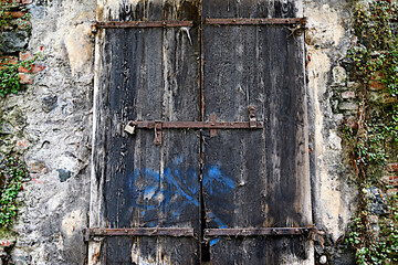 Old shutters of an ancient building that served as a gateway for hay.