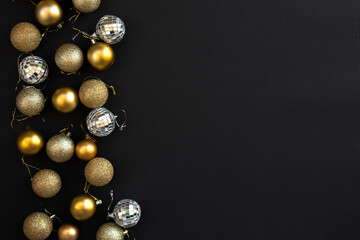 Christmas golden silver decoration balls on black background. Flat lay and Copy Space. Merry Christmas and Happy New Year.