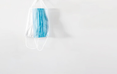 a pair of hanging surgical masks isolated on a white background