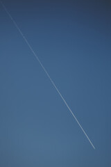 Fototapeta na wymiar Flying airplane trail in a clear sky