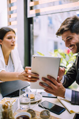 Hard work ensures success. Concentrated young woman using pc tablet with his partner